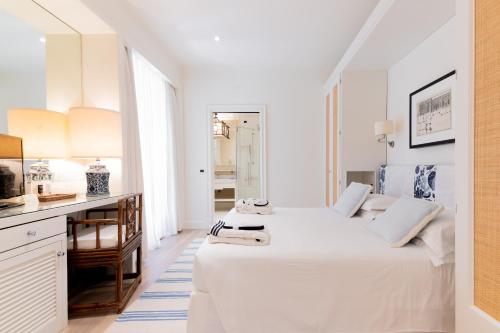 马尔米堡卡莉福尼亚花园酒店的一间白色卧室,配有两张床和一张书桌