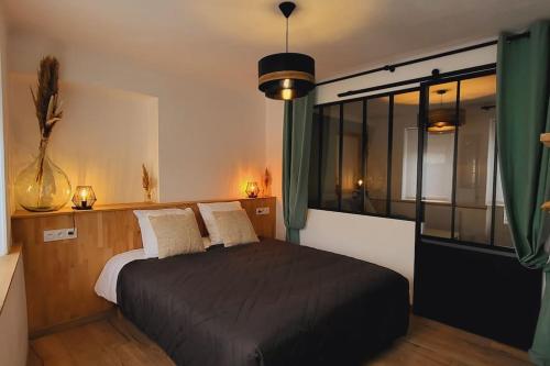 蓬托尔松Gîte Pontors'home Mont Saint-Michel的一间卧室设有一张黑色的床和一个窗户。