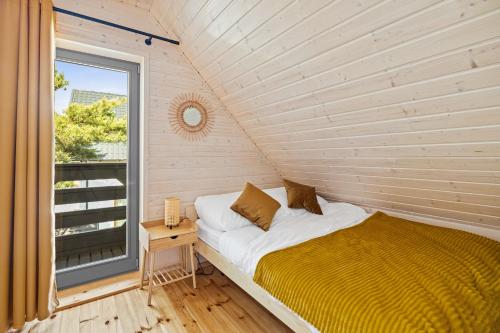 詹塔尔Natura Jantar - Całoroczne domy drewniane的窗户客房内的一张床位