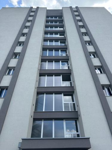 布拉迪斯拉发CASTLE HILL apt in Old Town of Bratislava with free parking的一座高高的公寓楼,设有许多窗户
