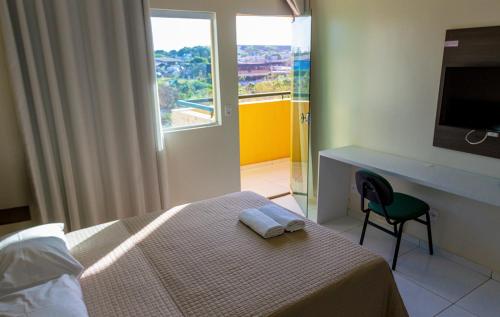 特雷西纳RILL HOTEL BY UCHÔA的一间卧室配有一张床、一张书桌和一个窗户。