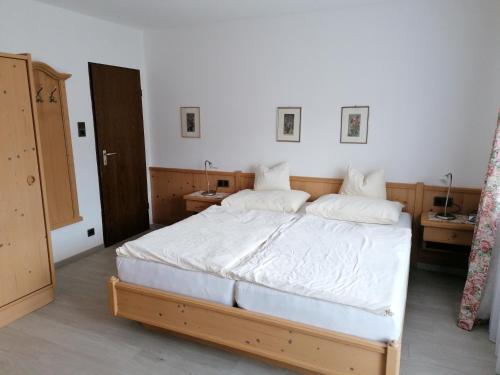 蒂罗尔-泽费尔德Landhaus Relly的一间卧室配有一张带白色床单的大床