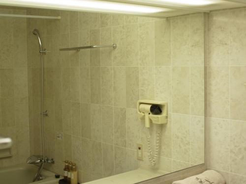 熊谷金大使熊谷酒店的带淋浴的浴室,墙上配有电话