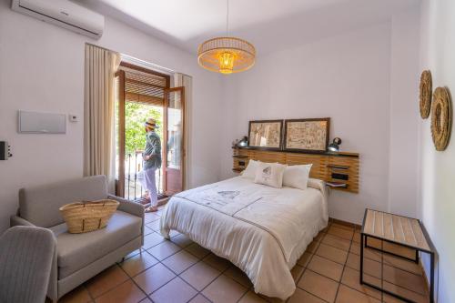 阿尔卡拉拉雷亚尔Casa el Aguardentero的一间卧室配有一张床和一把椅子