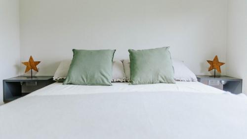 埃博森Madero departamentos的一张带绿色枕头的白色床和两张桌子