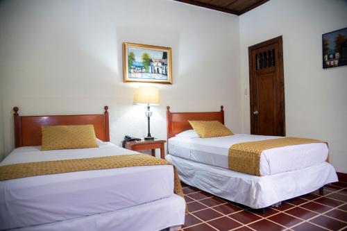 圣萨尔瓦多塞伦娜埃斯卡隆别墅酒店的酒店客房,设有两张床和一盏灯