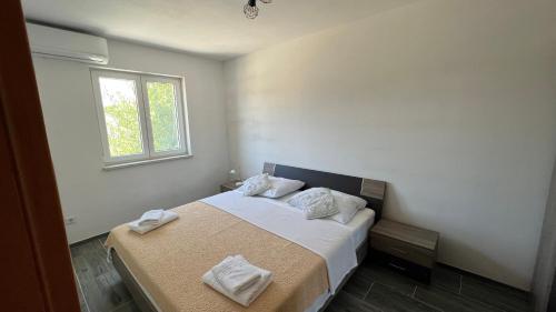 苏科尚Apartments MIJUTA的一间卧室配有一张带白色床单的床和一扇窗户。