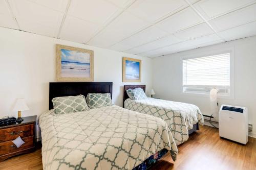 翡翠岛Hannahs Place - Quaint and Cozy Apt by the Beach!的卧室设有两张床,拥有白色的墙壁和木地板