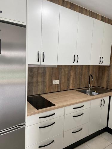 莫甘Puerto Rico Savage 3的厨房配有白色橱柜和不锈钢冰箱