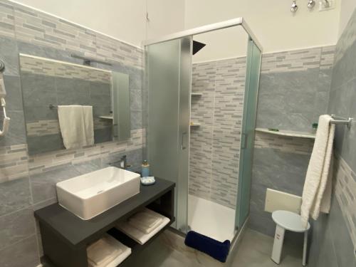 斯培西亚Titi Rooms的一间带水槽和玻璃淋浴的浴室
