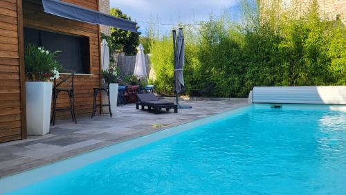 孔佩尔Le mas ROLLAND - Piscine & SPA - MILLAU-GORGES du TARN的一座带庭院的房屋前的游泳池