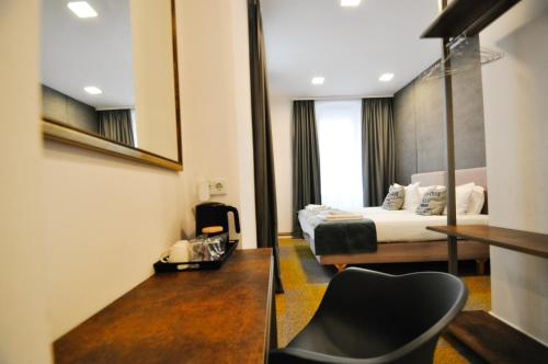 萨拉热窝Heritage Hotel Petrakija的配有一张床和一把椅子的酒店客房