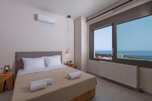 GállosLeon Luxury Home in Rethymno的一间卧室设有一张床和一个大窗户