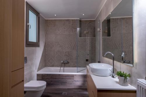 GállosLeon Luxury Home in Rethymno的带浴缸、盥洗盆和卫生间的浴室
