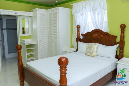 圣菲利普EHL Calypso Villa 4Bed 4.5baths, 5min to Beach的一间卧室配有带白色枕头的木床