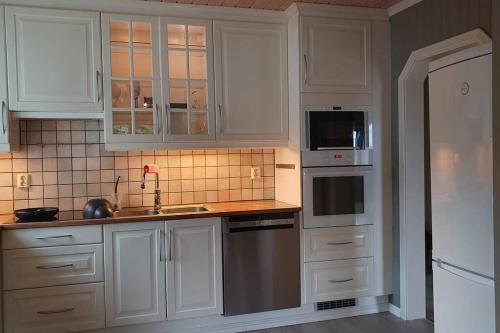 翁达尔斯内斯Moen Booking的厨房配有白色橱柜和不锈钢用具