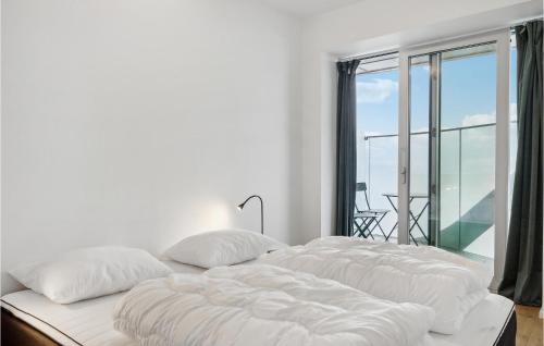 奥胡斯2 Bedroom Lovely Apartment In Aarhus C的带窗户的客房内的白色床和白色枕头