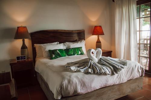 坎布塔尔Hotel Playa Cambutal的一间卧室配有一张带两个天鹅的床