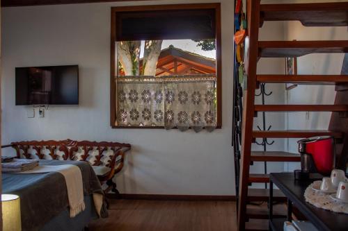 穆库热Villa Santo Antonio - Mucugê的一间卧室设有一张床,楼梯设有窗户