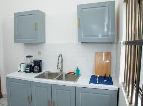 科托努Résidences Inaya的厨房配有白色橱柜和水槽