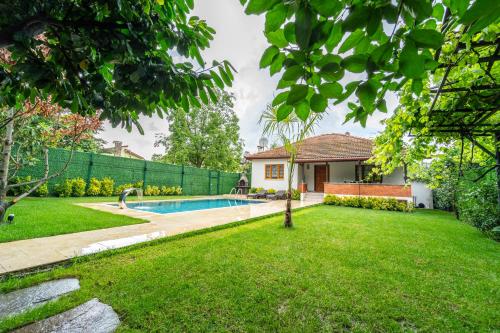 萨潘贾Sapancaminihouse的一个带游泳池和房子的庭院