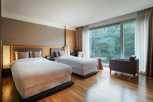 南原市南原套房酒店 的酒店客房设有两张床和窗户。