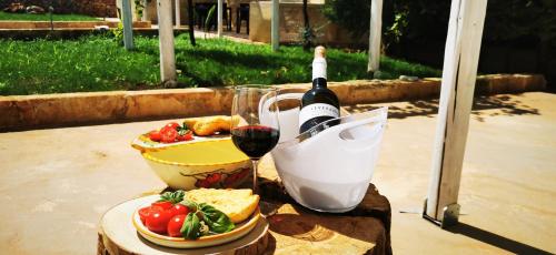 乌真托TORRE VECCHIA RELAIS的一张桌子,上面放着一瓶葡萄酒和一杯