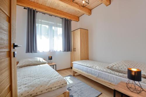 波拉齐克Brzozowa Osada的一间卧室设有两张床和窗户。