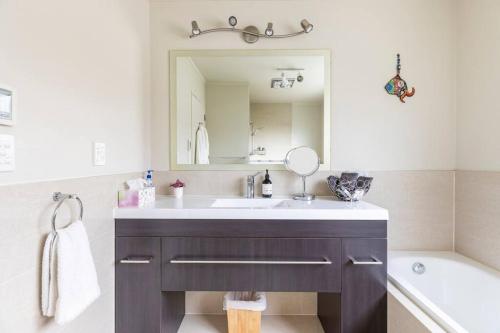 怀卡奈Quiet and cosy的浴室配有盥洗盆、镜子和浴缸