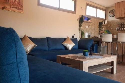杰迪代Lake House Boulaouane的客厅配有一张蓝色的沙发,配有一张桌子