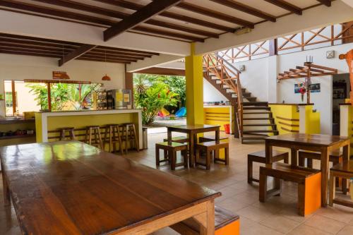 别霍港Pagalù Hostel的一间带木桌和椅子的餐厅以及楼梯