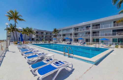 基克罗尼海滩Your Happy Place ON THE BEACH!的酒店旁的游泳池设有躺椅