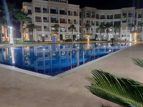 布兹尼盖COSTA BEACH Lux Family Apartment with Pools的晚上在酒店前面的一个游泳池