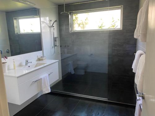 凯里凯里Te Whare Ma的一间带水槽、淋浴和卫生间的浴室
