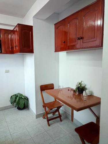 库斯科Casa QENTE的厨房配有木桌和木橱柜。