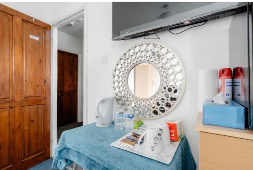 海斯North Avenue, Guest House, Heathrow Airport-Free Parking的浴室设有一张桌子和墙上的镜子