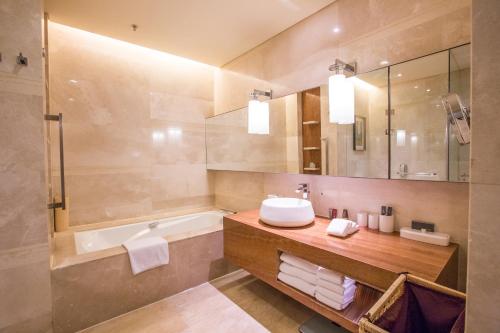 天津天津万豪行政公寓的一间带水槽、浴缸和镜子的浴室