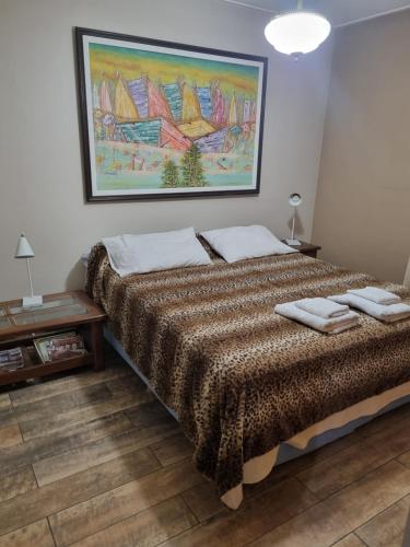 门多萨Tabanera suite的卧室配有一张床,墙上挂有绘画作品