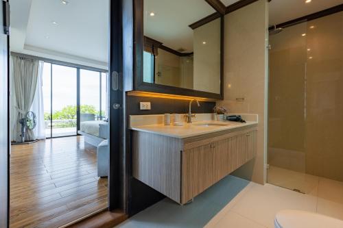 华欣BeachFront Modern 4 Bedroom Pool Villa RV的一间带水槽和镜子的浴室