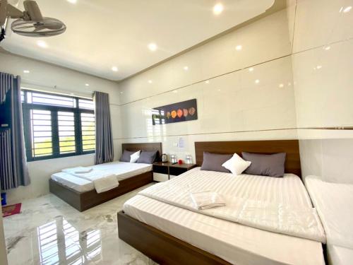 平州Motel Hòa Hiệp的一间卧室设有两张床和大窗户