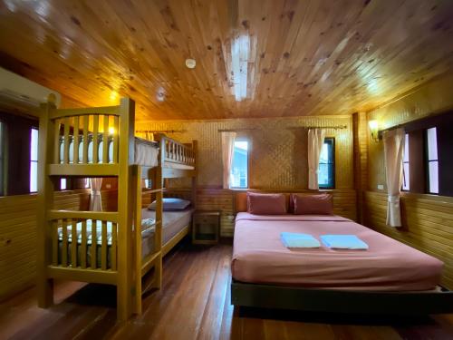 清莱松村拜安度假酒店的一间卧室设有两张双层床和梯子