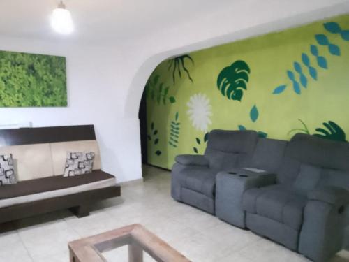 墨西哥城Casita del Árbol的带沙发和绿色墙壁的客厅