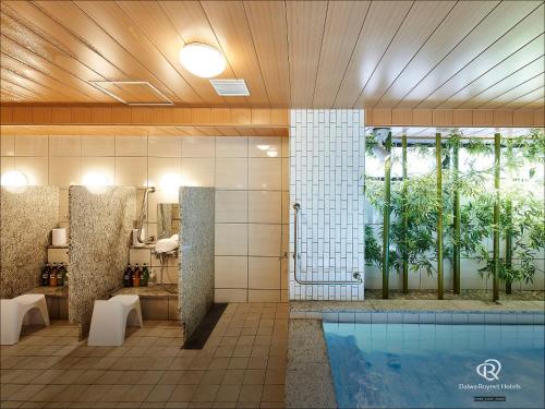 名古屋Daiwa Roynet Hotel Nagoya Fushimi的浴室设有游泳池,位于浴缸旁