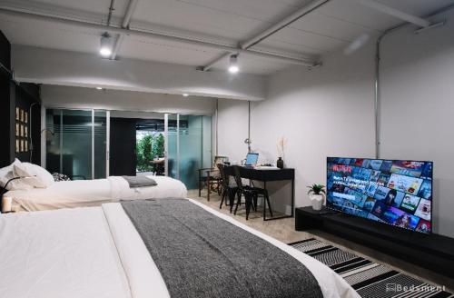 清莱Bedsment的一间卧室配有两张床和一台平面电视