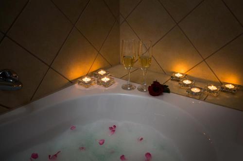 耶尔萨Hotel Hvar的浴缸配有两杯葡萄酒和蜡烛
