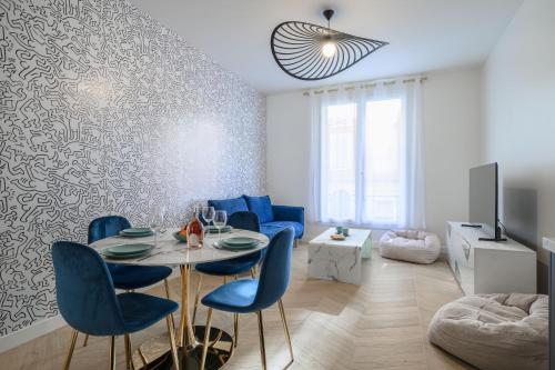 尼斯Le Walesa, magnifique 3P, spacieux et rénové, Port de Nice的客厅配有桌子和蓝色椅子