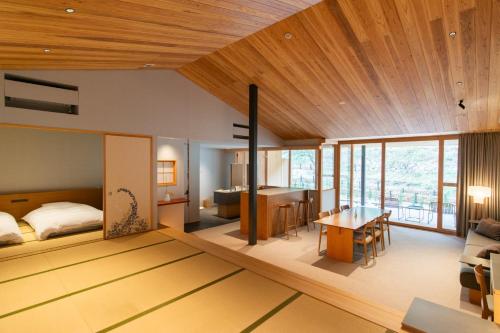 直岛町Naoshima Ryokan Roka的一间卧室和一间带一张床铺和一张桌子的客厅