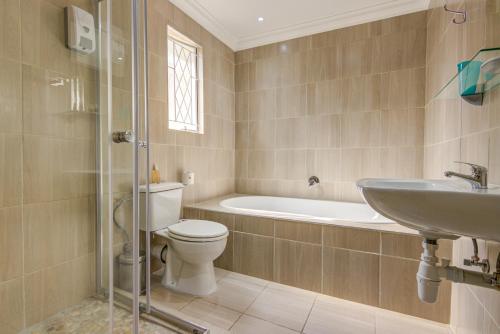 伊登维尔Edenvale Guest House的浴室配有卫生间、盥洗盆和浴缸。