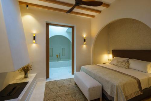厄尔·坎皮洛·德·罗达尔Cortijo Boutique Siete Calas的一间卧室设有一张大床和一个浴缸