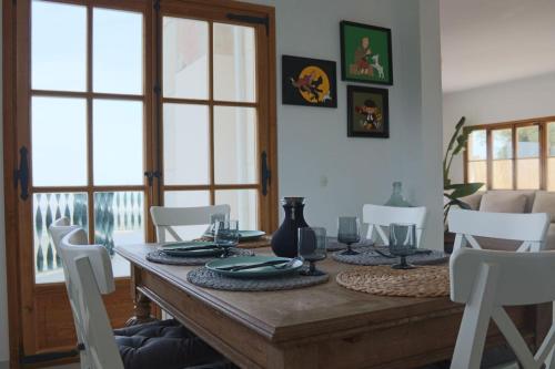 埃斯波尔莱斯Finca Es Verger的一间带木桌和白色椅子的用餐室